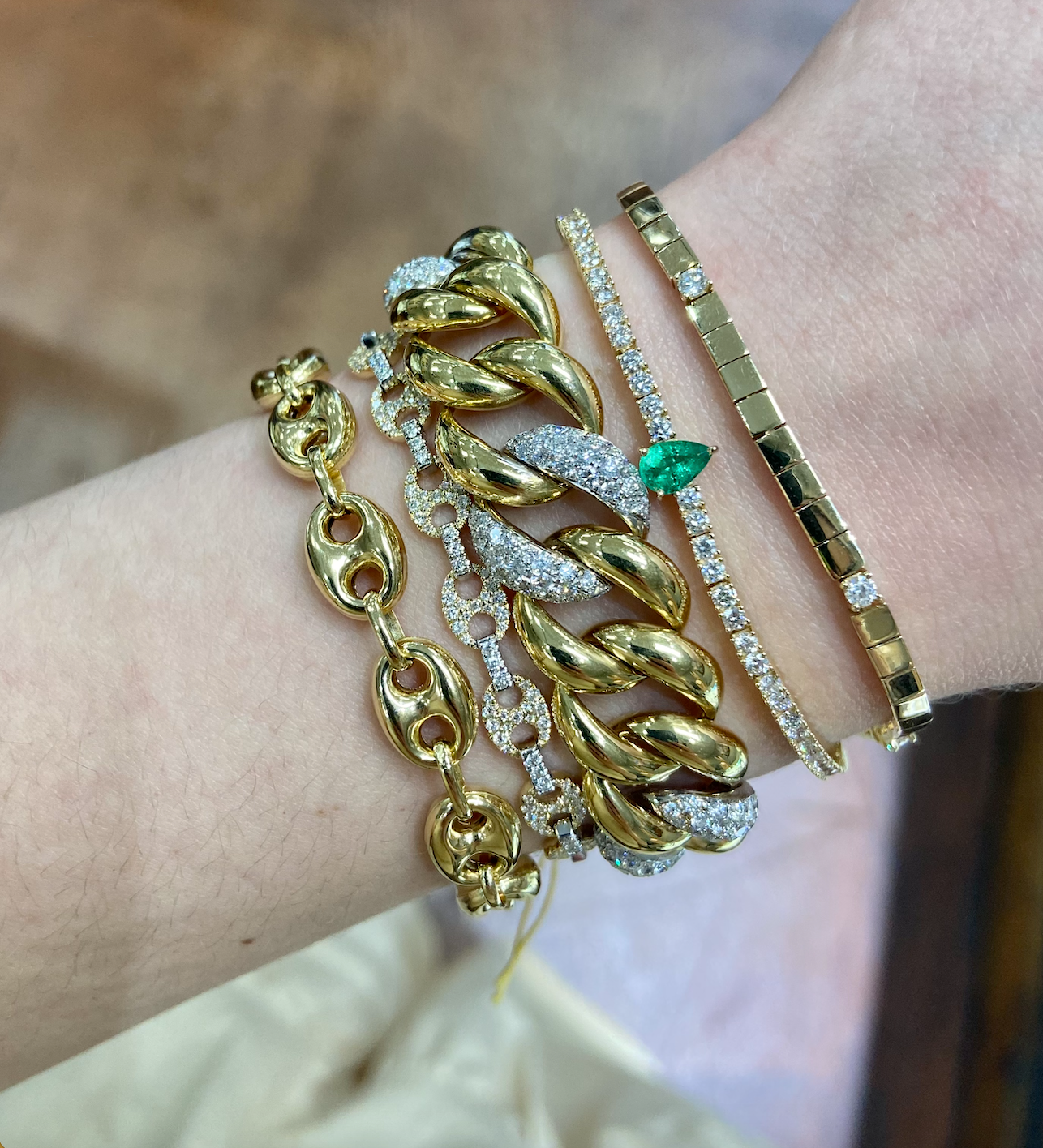 Layered 14k gold bracelet stack showing balanced proportions Layered 14k gold bracelet stack showing balanced proportions